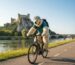 Ours polaire faisant du vélo électrique à Valence sur la ViaRhôna face au Château de Crussol.